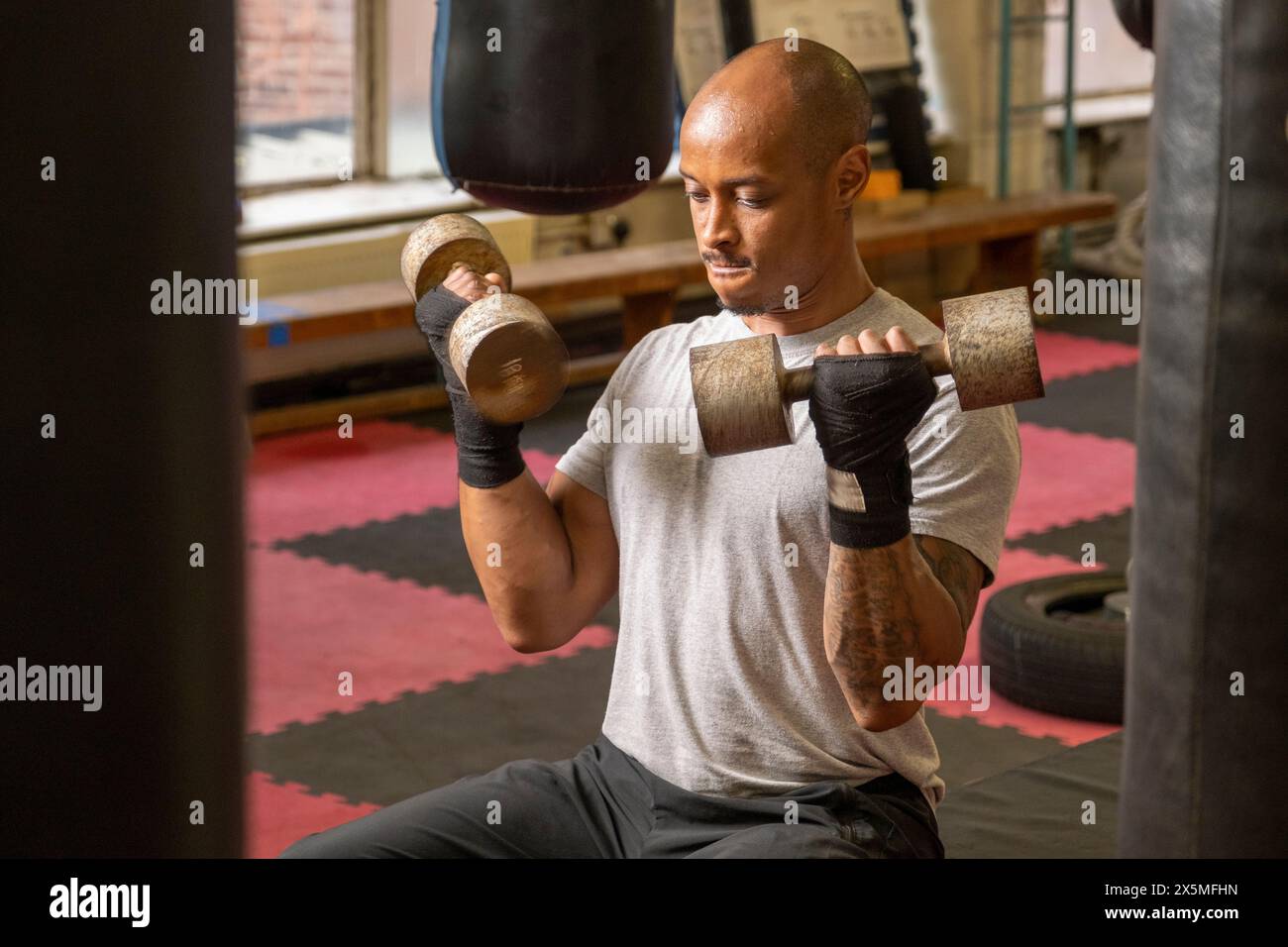 Uomo maturo che solleva manubri in palestra Foto Stock