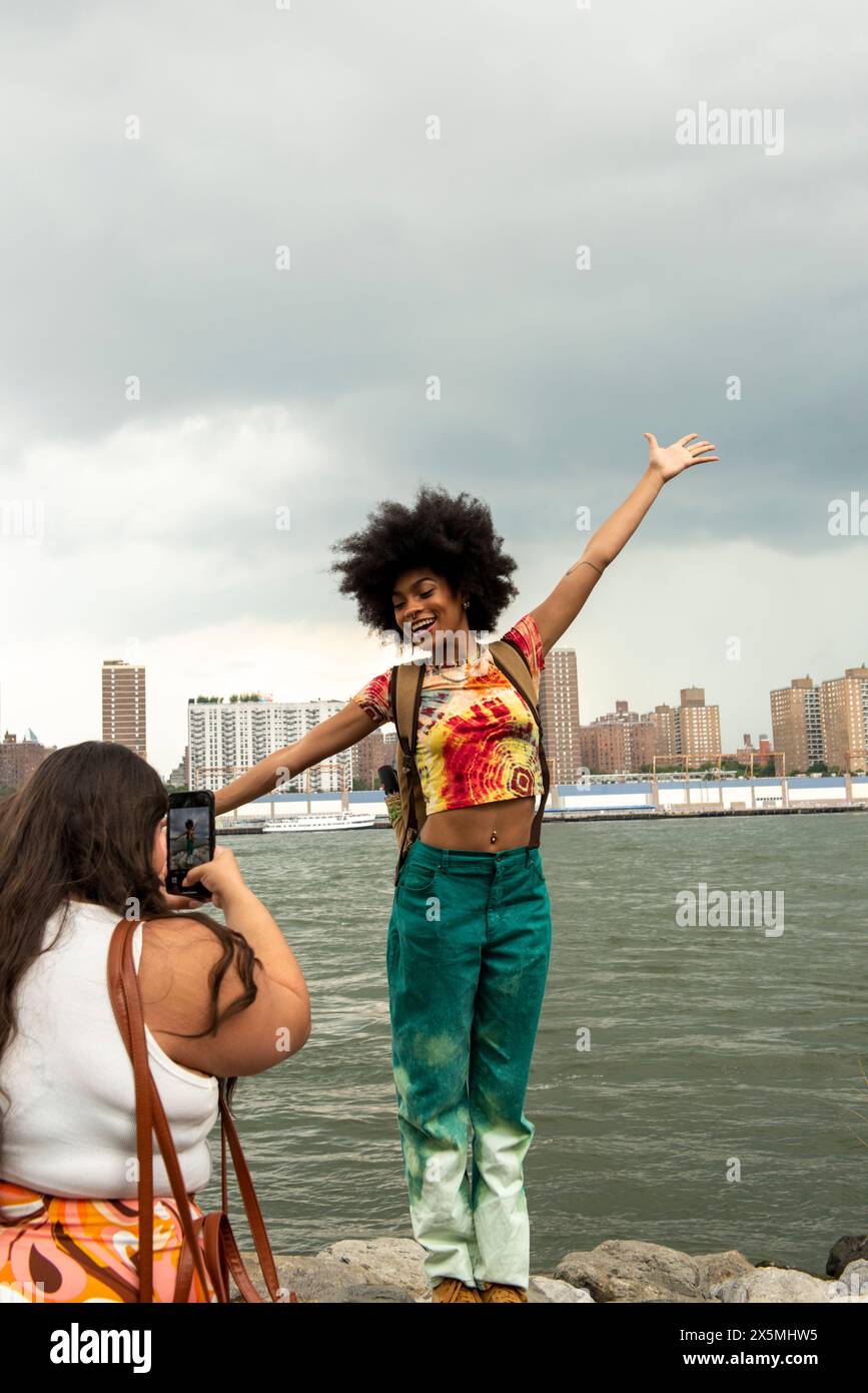 USA, New York City, due donne che fanno foto al fiume Foto Stock