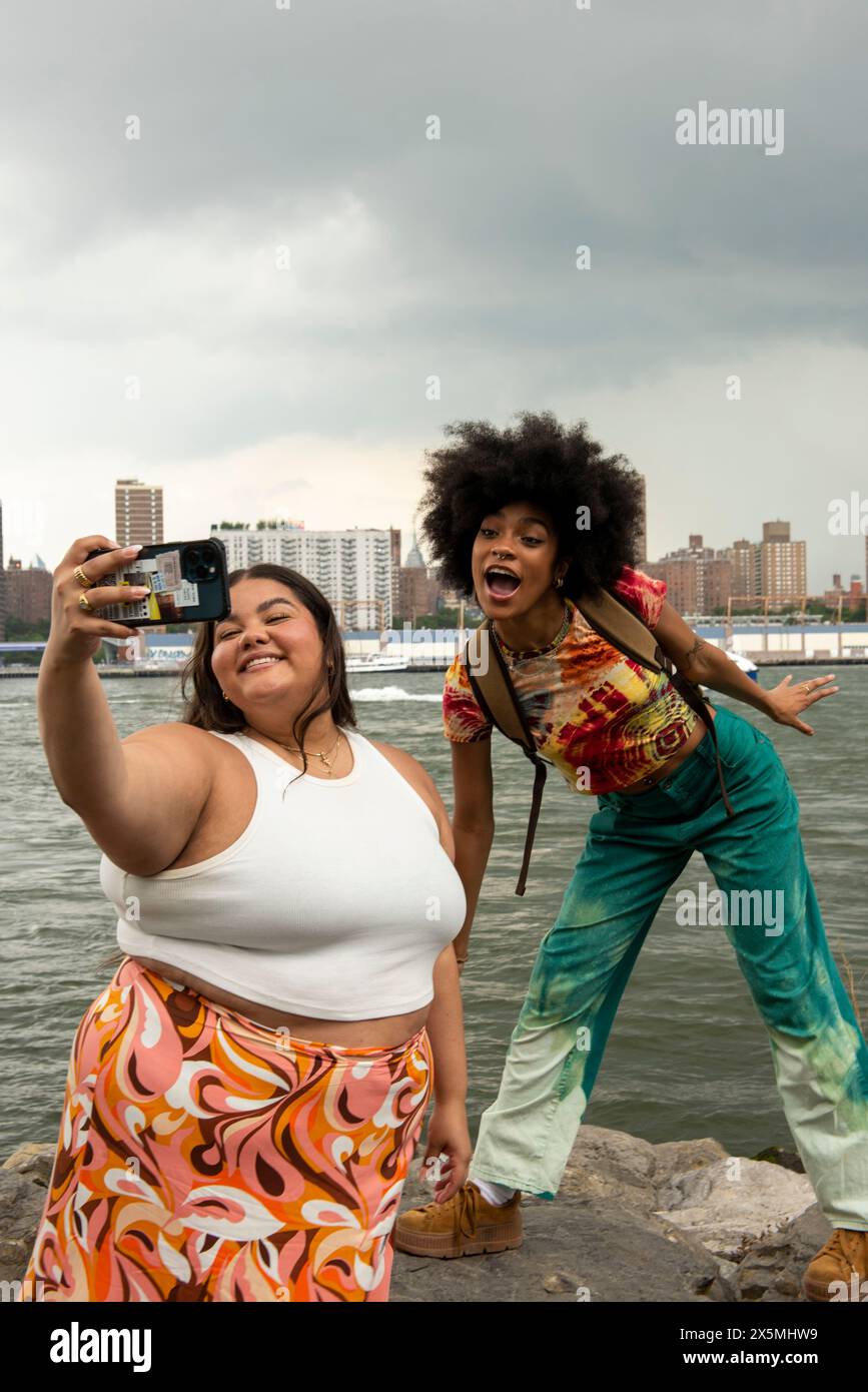 USA, New York City, due donne che fanno foto al fiume Foto Stock