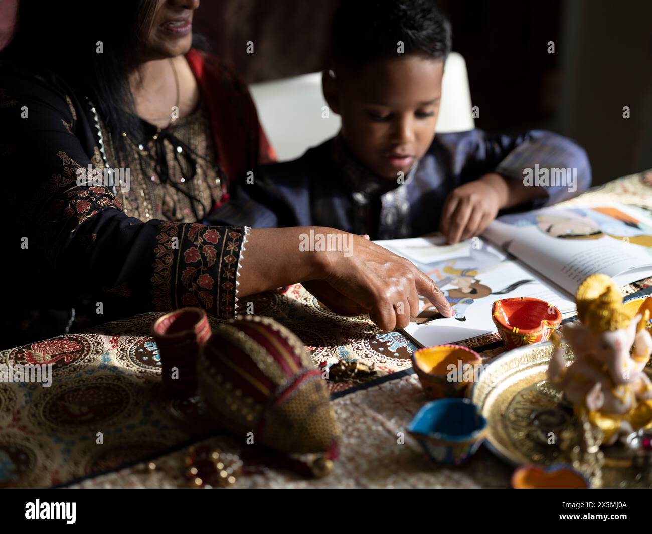 Nonna e nipote leggono un libro prima della celebrazione del Diwali Foto Stock