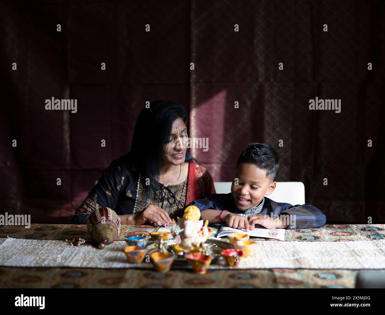 Nonna e nipote leggono un libro prima della celebrazione del Diwali Foto Stock