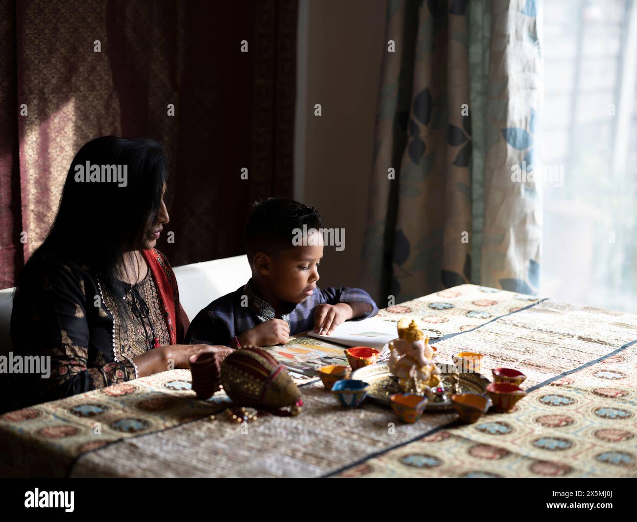 Nonna e nipote leggono un libro prima della celebrazione del Diwali Foto Stock