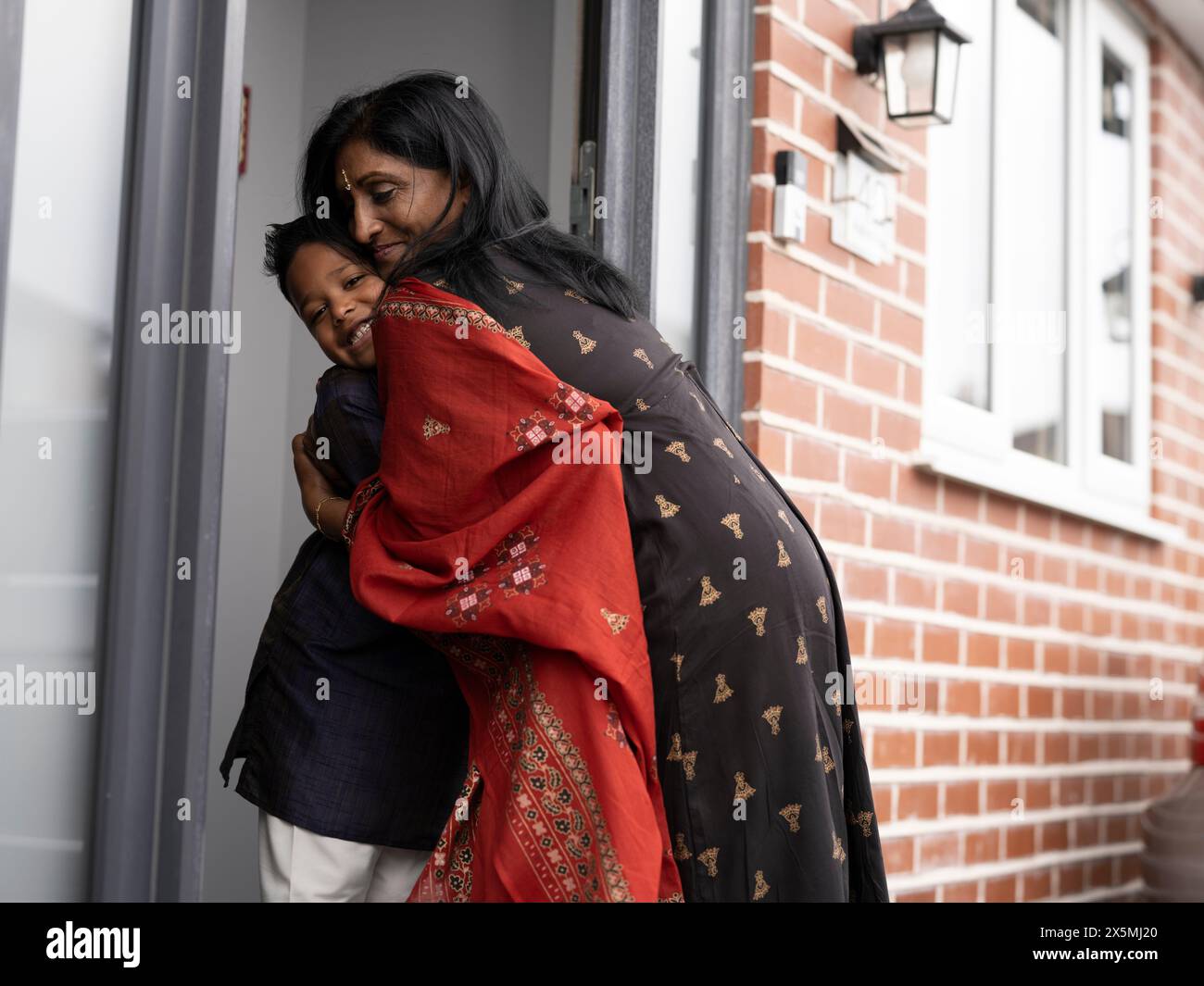 Donna in visita al nipote per Diwali Foto Stock