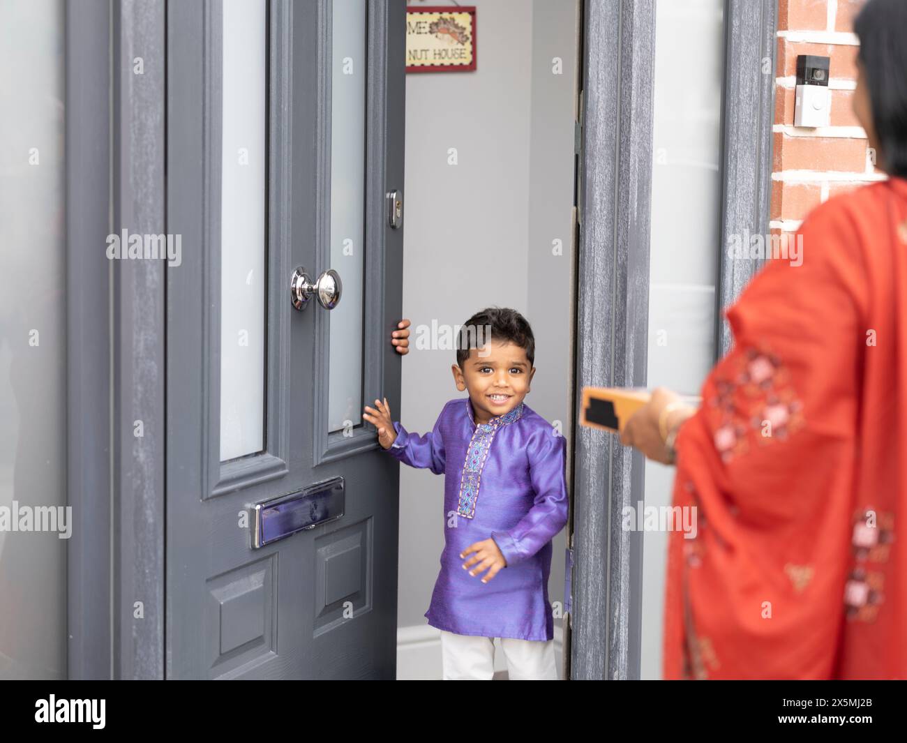 Donna in visita al nipote con un regalo per Diwali Foto Stock