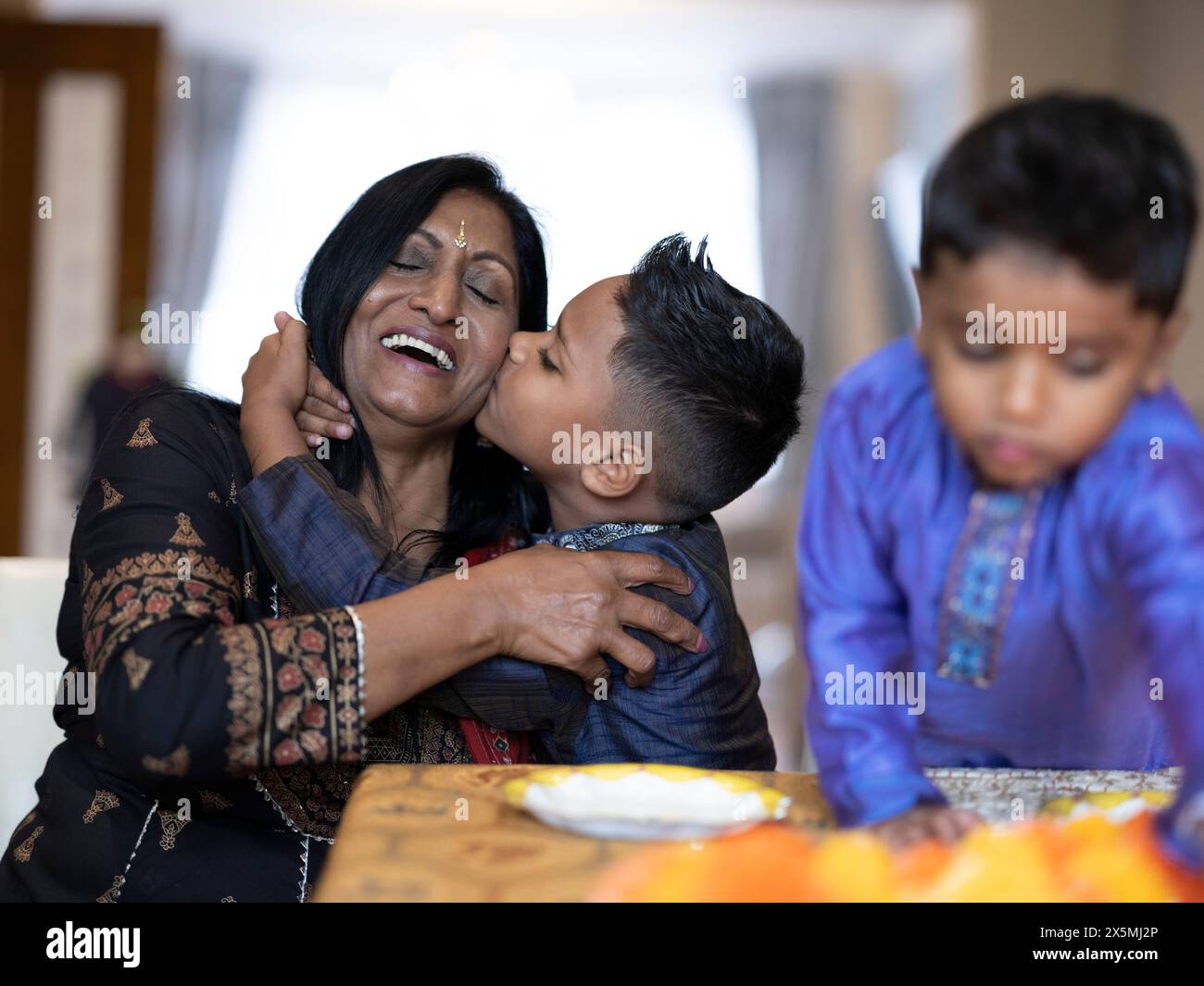 Ragazzo che bacia nonna durante la celebrazione Diwali Foto Stock
