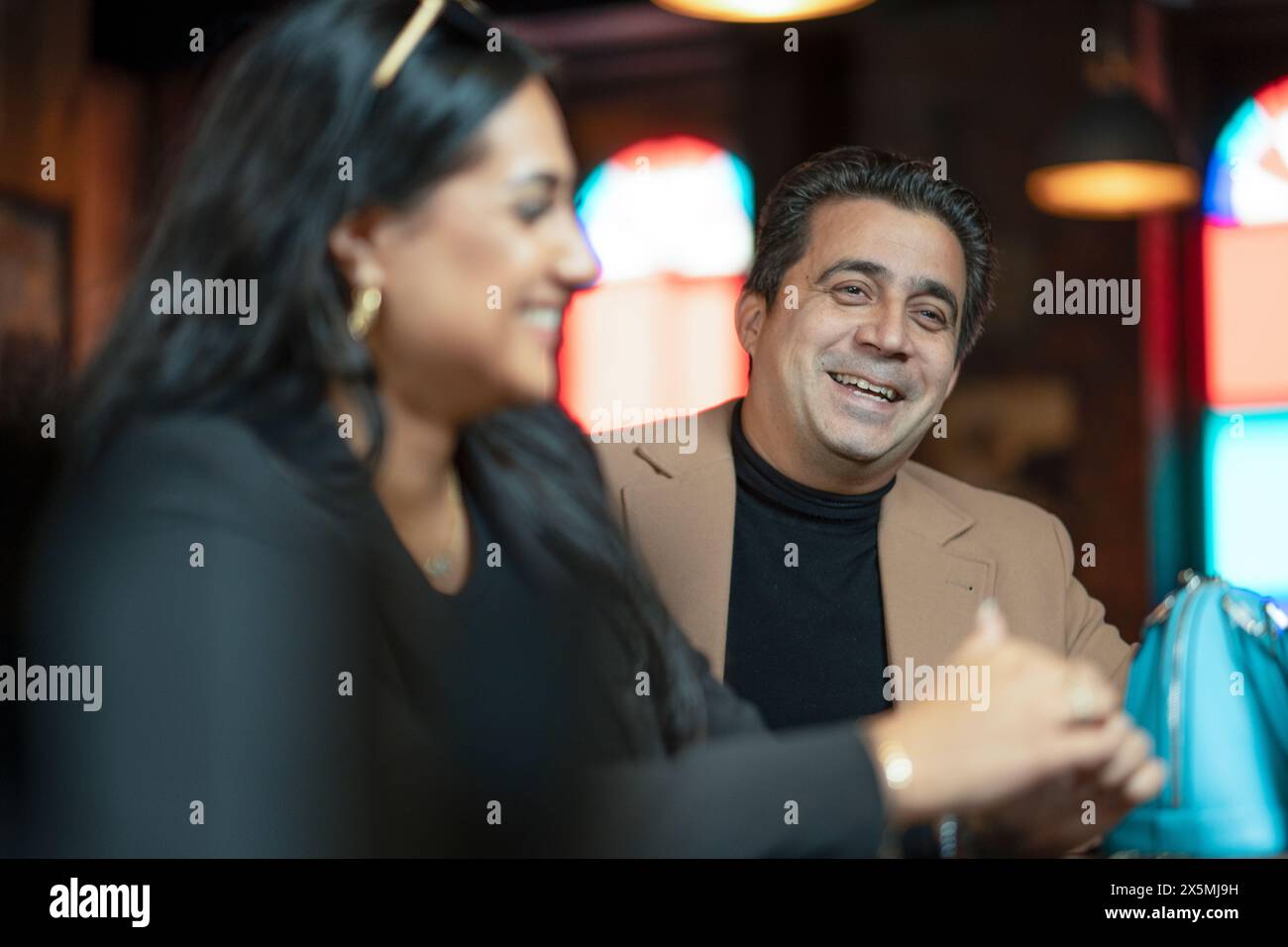 Uomo e donna sorridenti seduti al bar Foto Stock