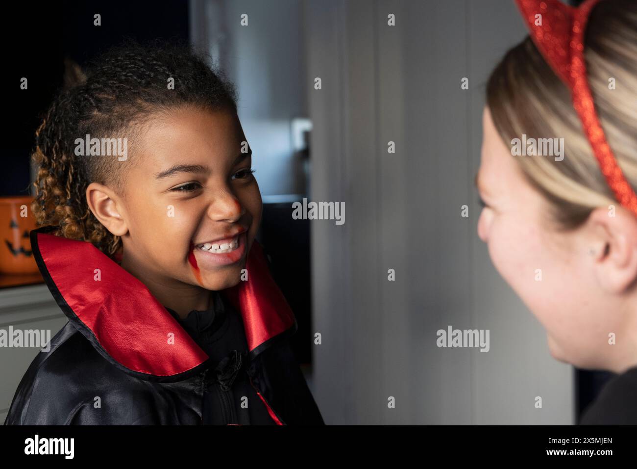 Primo piano di una donna sorridente con un figlio vestito da vampiro per Halloween Foto Stock