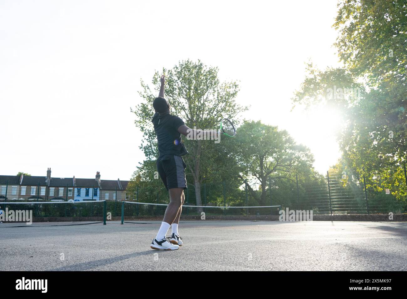 Uomo che gioca a tennis sul campo di quartiere Foto Stock