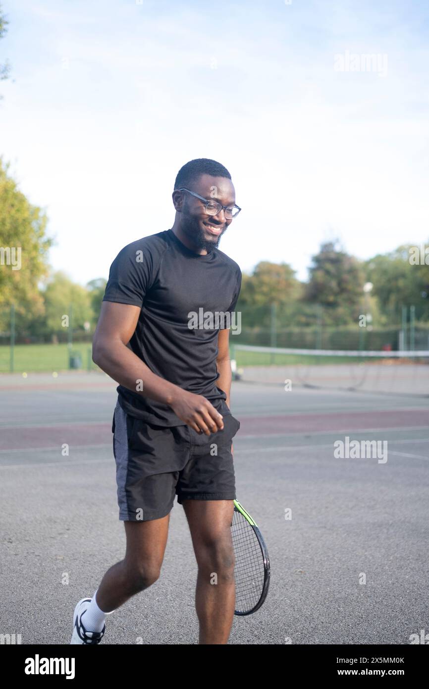 Uomo che gioca a tennis sul campo di quartiere Foto Stock