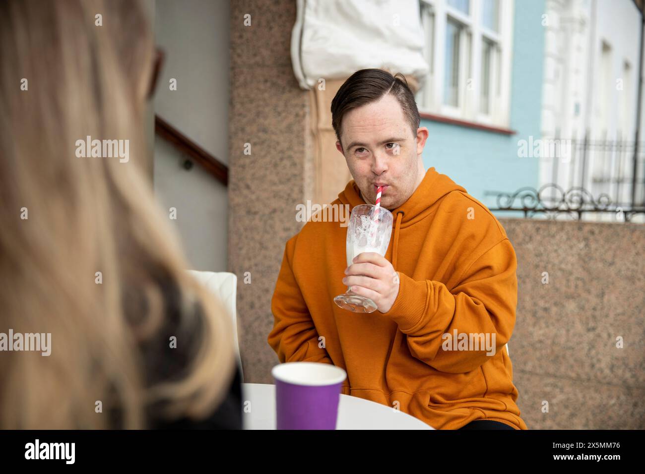 Uomo e donna seduti a un tavolo nel caffè marciapiede Foto Stock