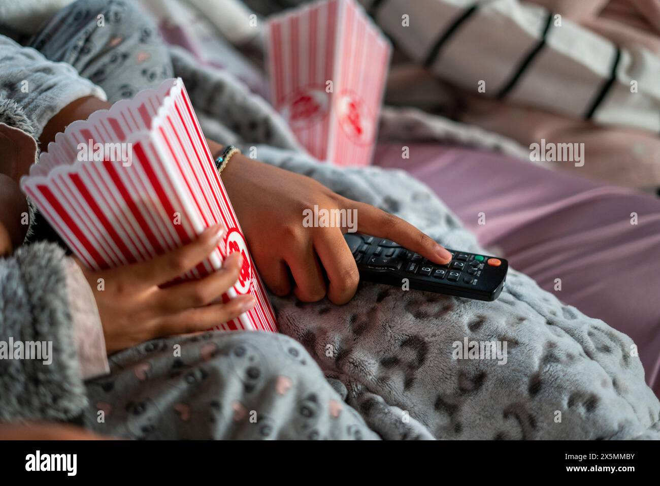 Primo piano di sorelle con telecomando e popcorn Foto Stock