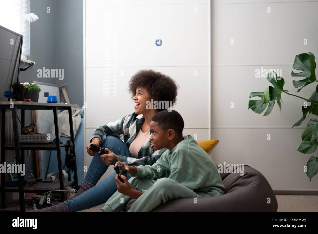 Madre e figlio giocano ai videogiochi a casa Foto Stock