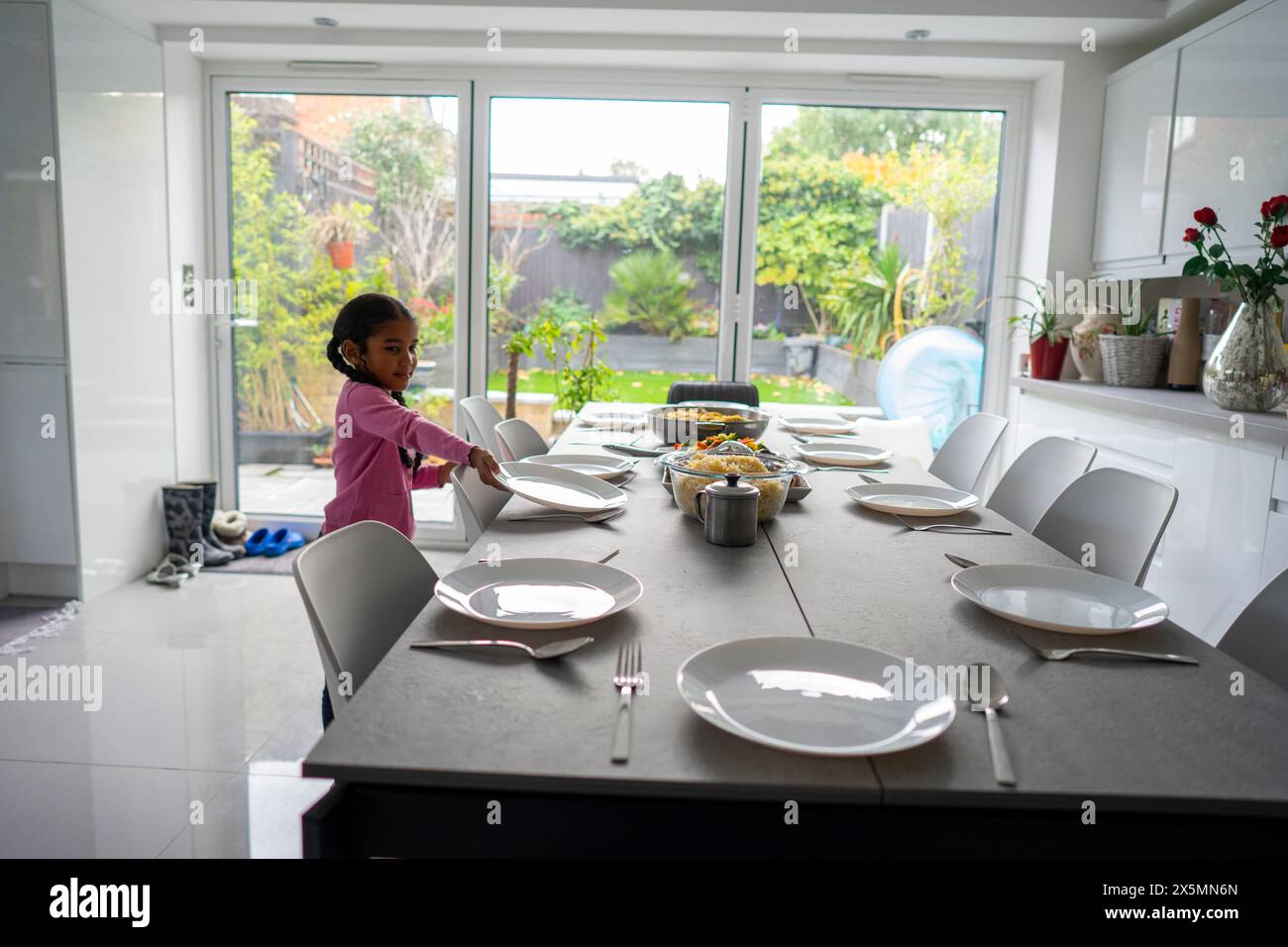 Ragazza che prepara il tavolo per la cena Foto Stock