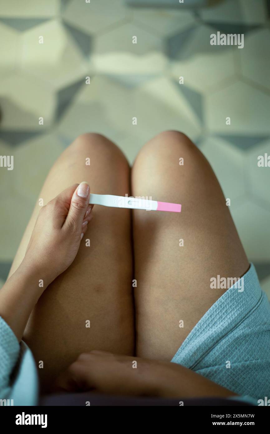 Primo piano di una donna che tiene il test di gravidanza Foto Stock