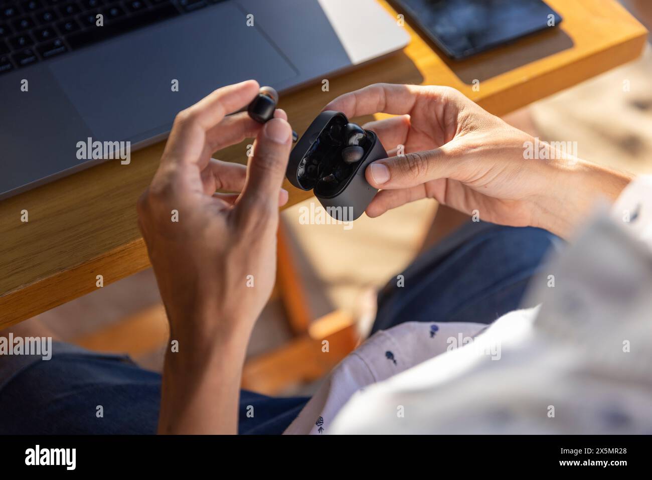 Uomo che blocca gli auricolari nella scatola, primo piano Foto Stock