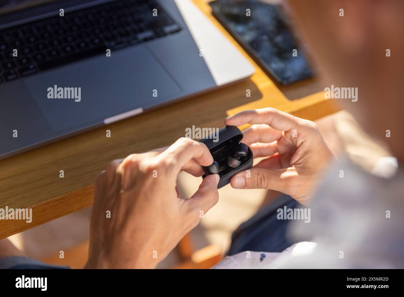 Uomo che blocca gli auricolari nella scatola, primo piano Foto Stock