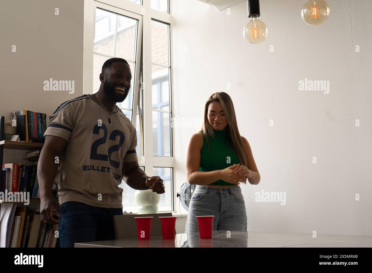 Amici che giocano a beer pong a casa Foto Stock