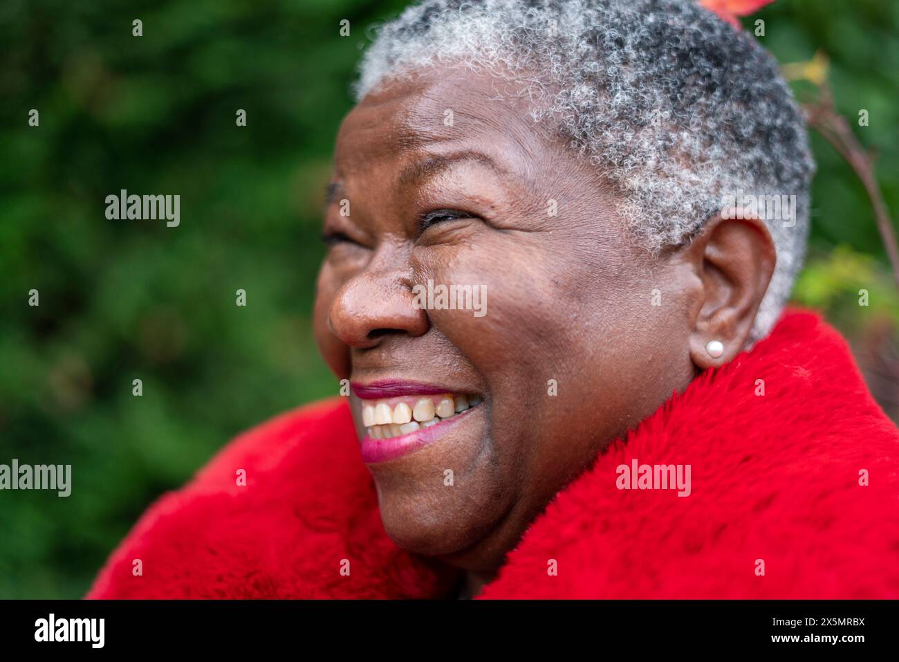 Ritratto di una donna anziana che indossa un cappotto di pelliccia rossa Foto Stock