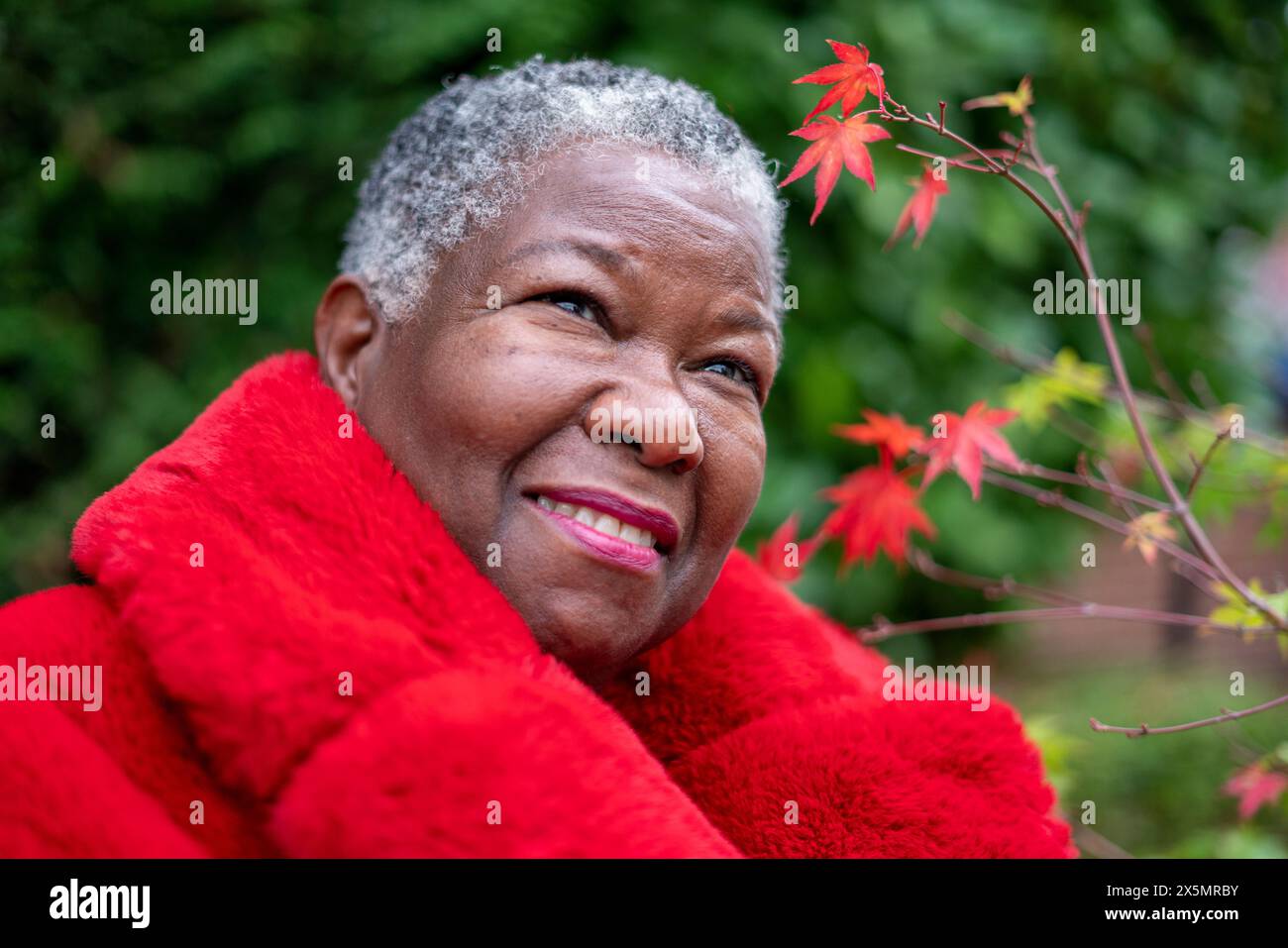 Ritratto di una donna anziana che indossa un cappotto di pelliccia rossa Foto Stock