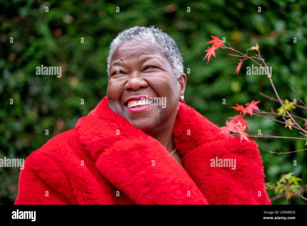 Ritratto di una donna anziana che indossa un cappotto di pelliccia rossa Foto Stock