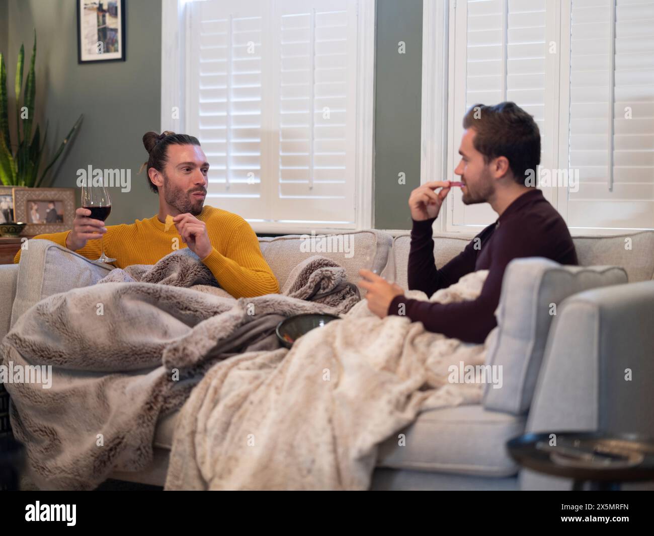 Coppia gay che si rilassa sul divano a casa Foto Stock