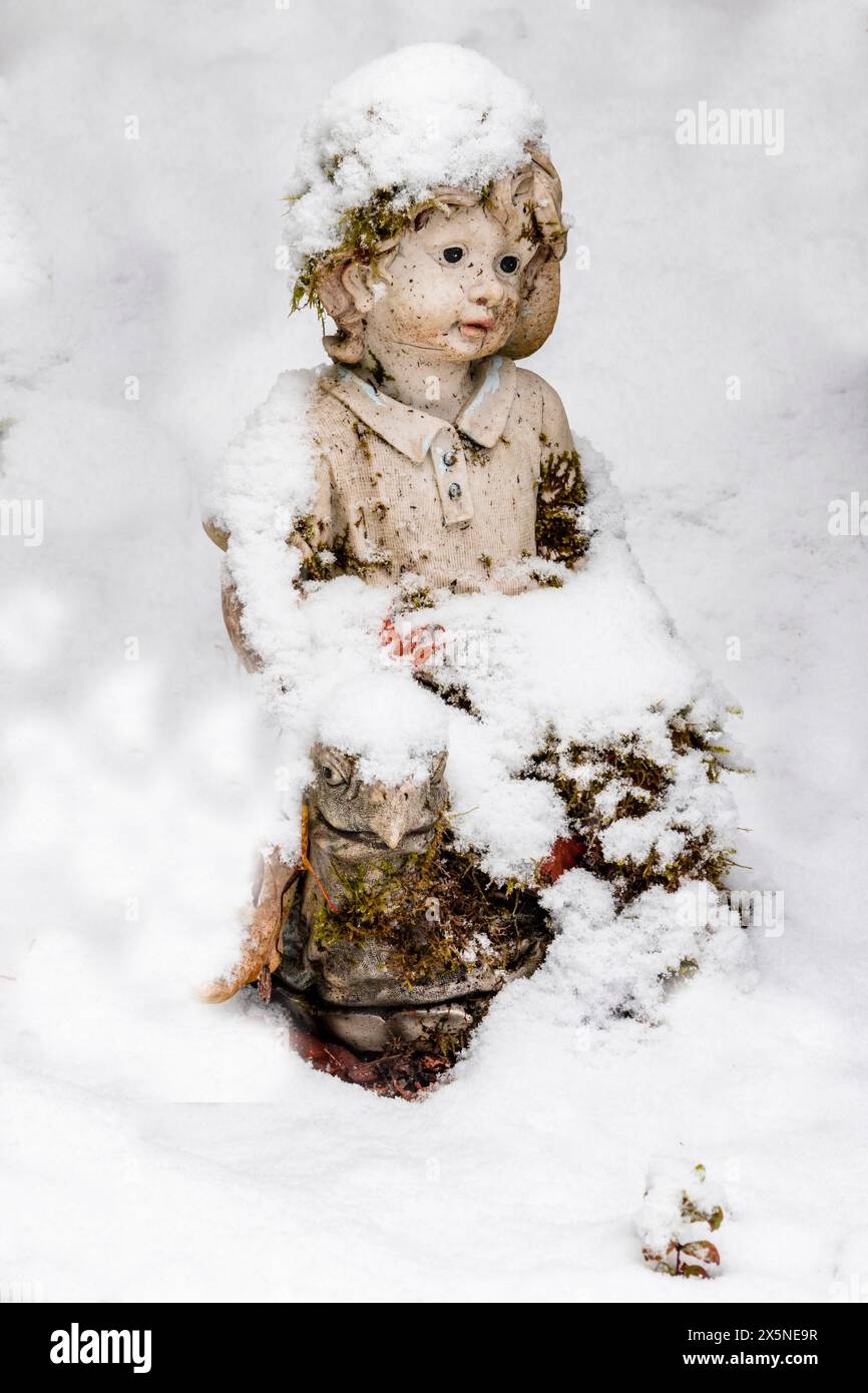 Stati Uniti, Stato di Washington, Sammamish. La neve fresca cade nell'arte del giardino nel cortile Foto Stock