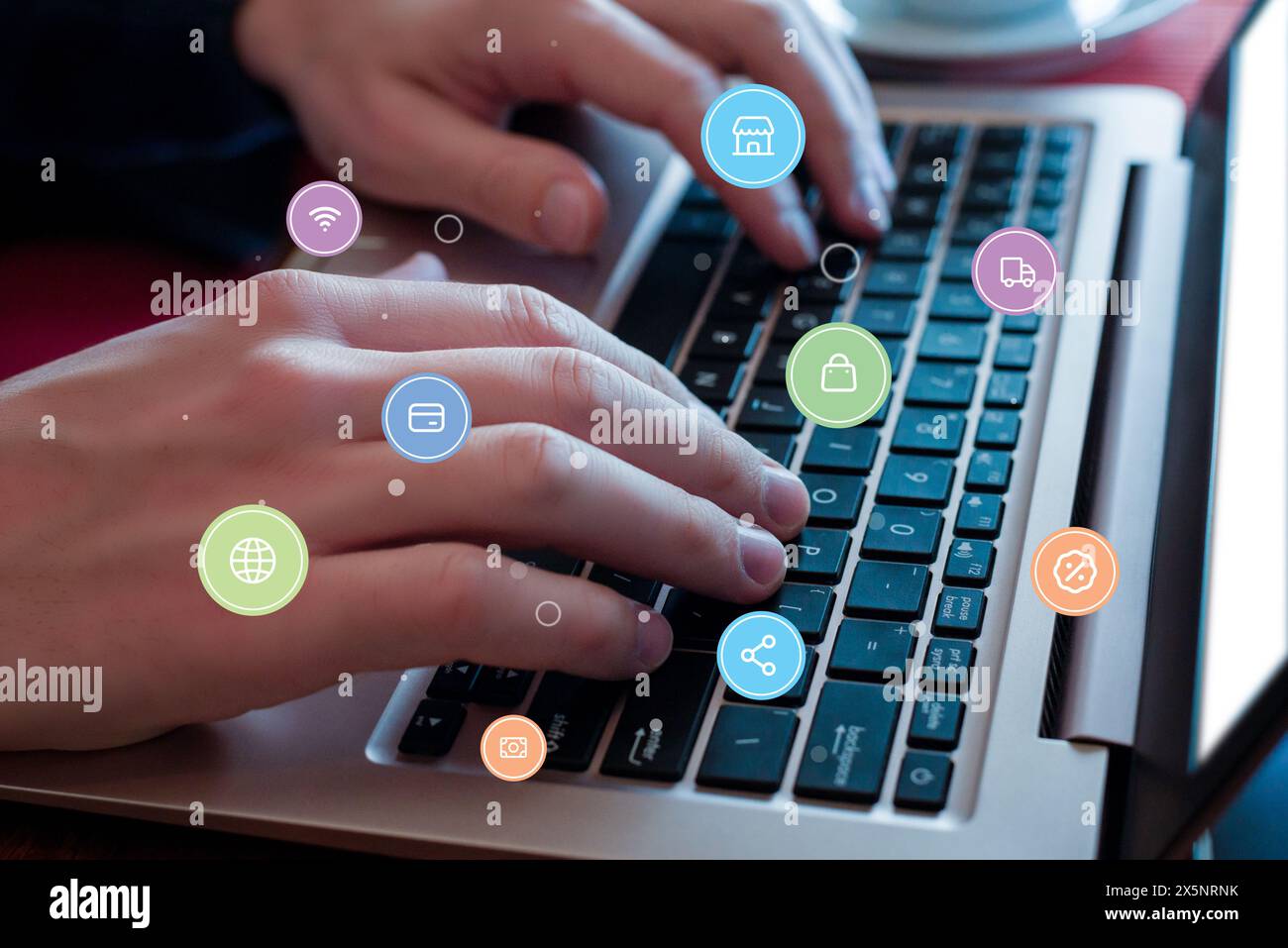 Digitazione manuale sulla tastiera del notebook con icone a levitazione: Carta di credito, negozio, denaro, sconto. Concetto di un'esperienza di shopping online senza interruzioni Foto Stock