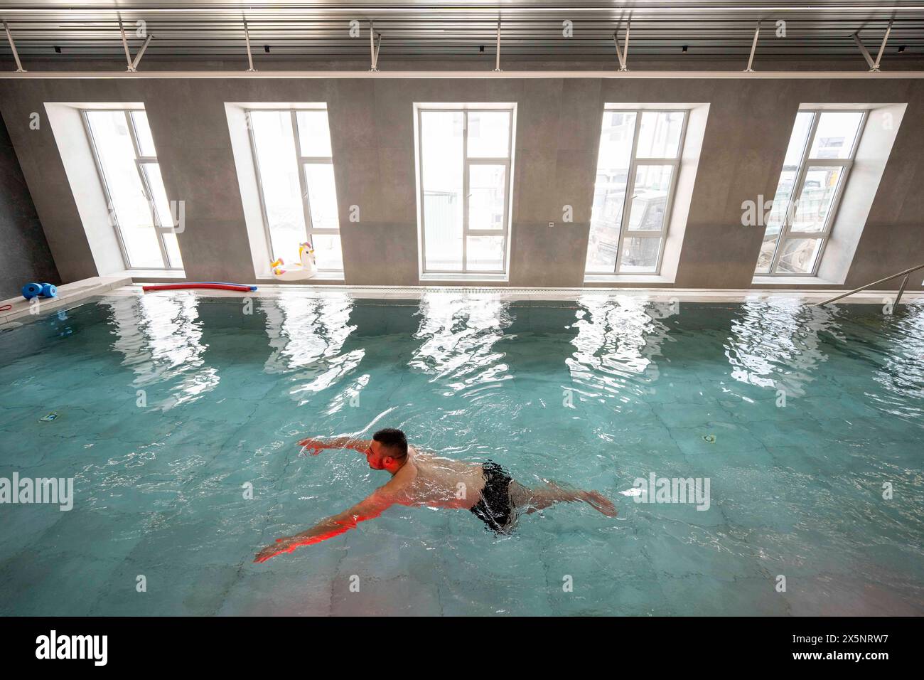 Persone che si allenano a lavorare senza gli arti persi in una piscina del centro superumani nell'Oblast' di Leopoli. Sono assistiti dal personale. Il centro è un moderno centro tutto ucraino per protesi, chirurgia ricostruttiva e riabilitazione per le vittime di guerra, sia civili che militari. Oblast di Leopoli *** persone che si allenano a lavorare senza arti persi in una piscina presso il Centro superumani nell'Oblast di Leopoli sono assistite dal personale il centro è un centro moderno tutto ucraino per protesi, chirurgia ricostruttiva e riabilitazione per le vittime di guerra, sia civili che militari di Leopoli Foto Stock