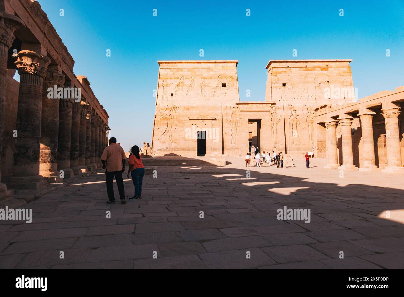 Turisti che esplorano l'antico Tempio di file ad Assuan, Egitto Foto Stock