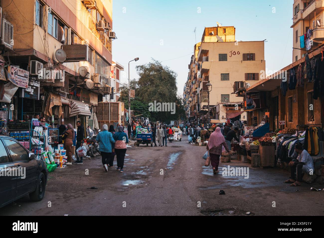 Una strada trafficata con varie bancarelle che vendono cibo e abbigliamento nella città di Assuan, in Egitto Foto Stock