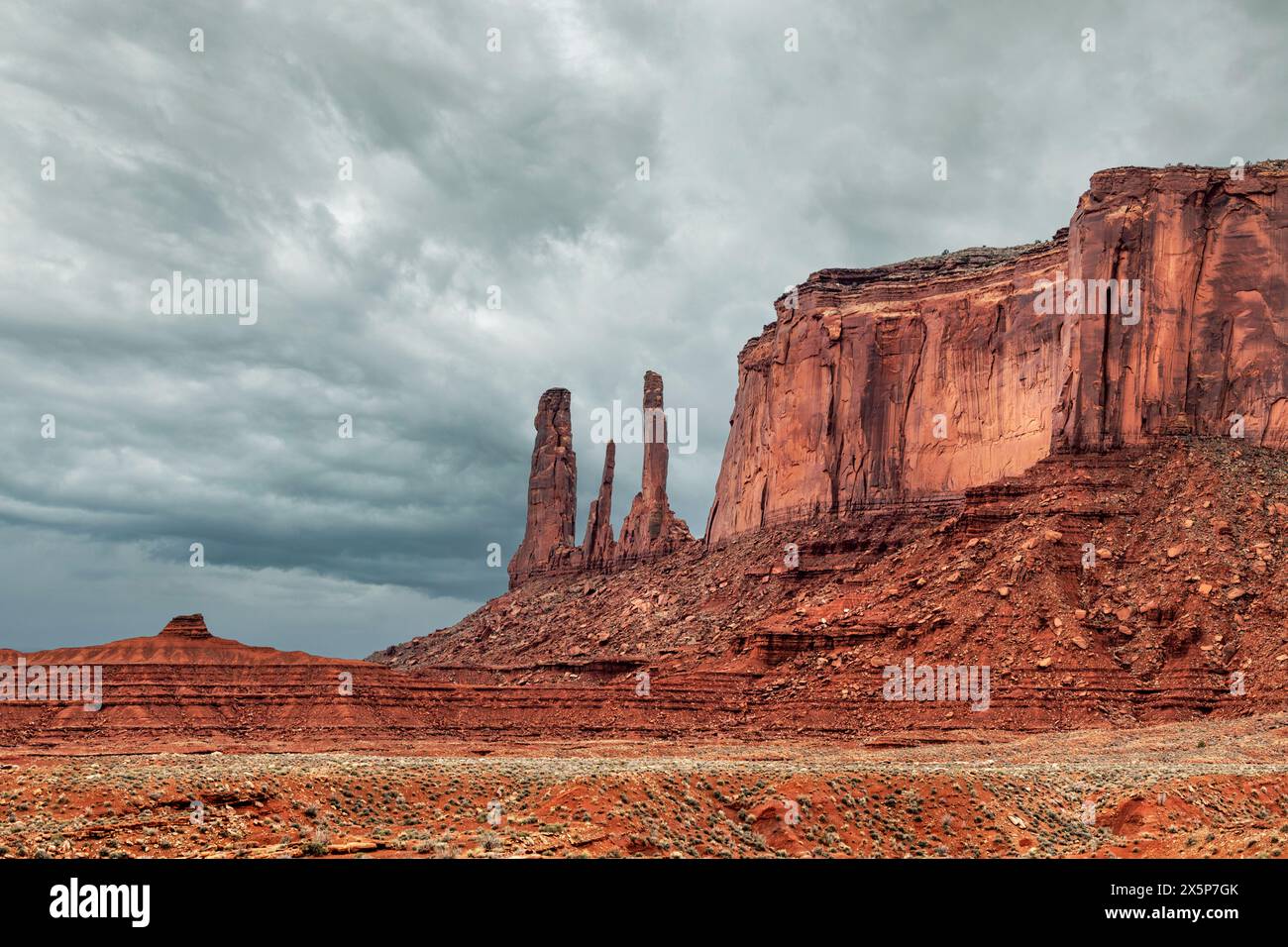 Famous Three Sisters nella Monument Valley è un residuo altamente eroso di una butte e sorge accanto a una lunga catena montuosa di arenaria, moenkopi e. Foto Stock