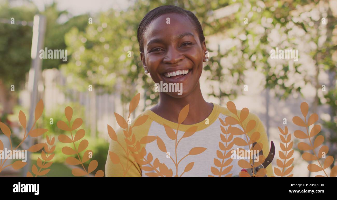 Donna afroamericana in piedi all'aperto, con indosso una camicia gialla, sorridente Foto Stock
