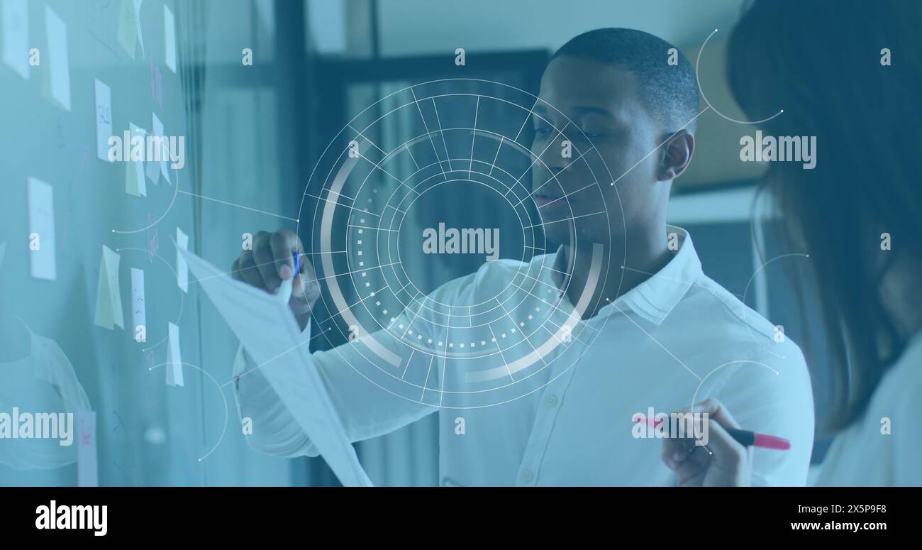 Il responsabile del marketing nero e del design bianco esaminano i grafici aziendali. Foto Stock