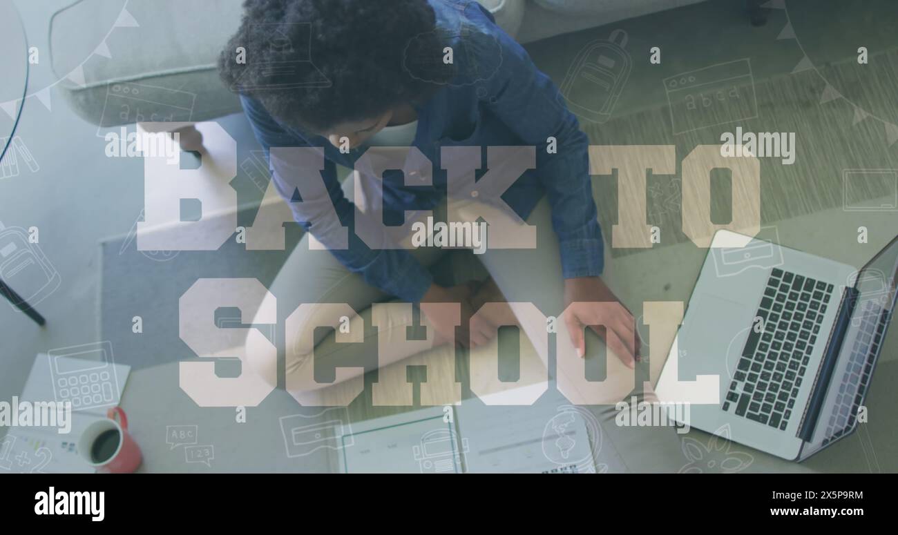 La donna nera di mezza età lavora su un notebook mentre la scuola riprende Foto Stock