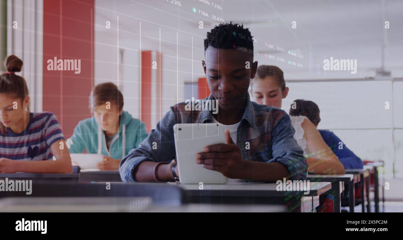 Immagine dell'elaborazione dei dati del mercato azionario su un ragazzo afroamericano che usa un tablet digitale a scuola Foto Stock