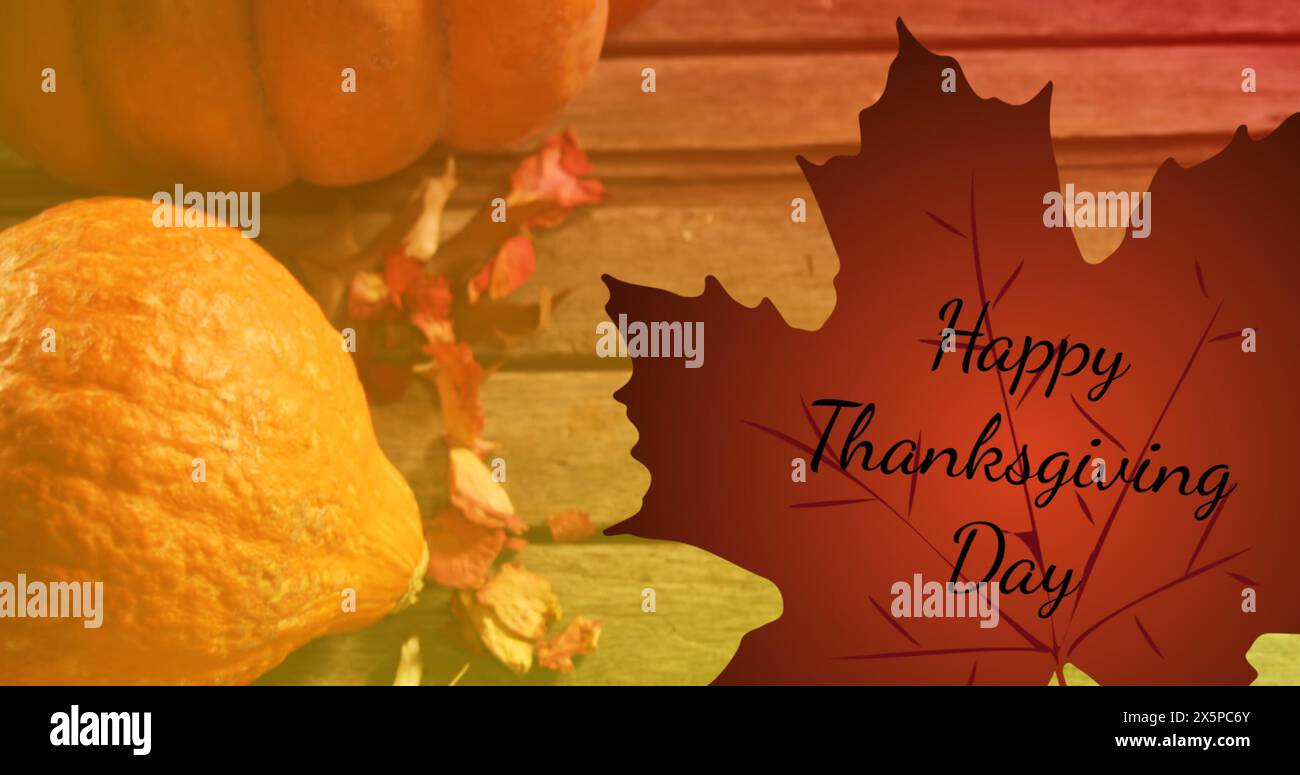 Immagine del testo del felice giorno del ringraziamento su foglie autunnali e zucche su sfondo in legno Foto Stock