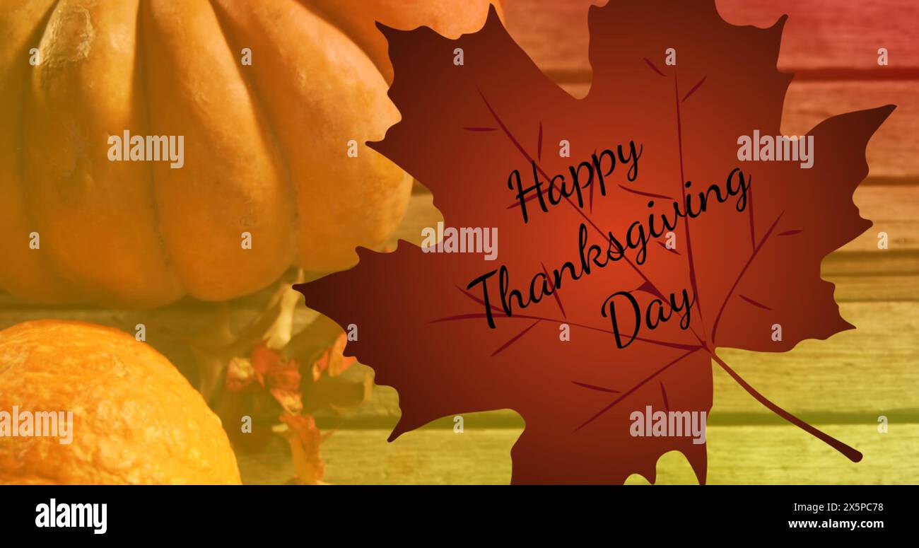 Immagine del testo del felice giorno del ringraziamento su foglie autunnali e zucche su sfondo in legno Foto Stock