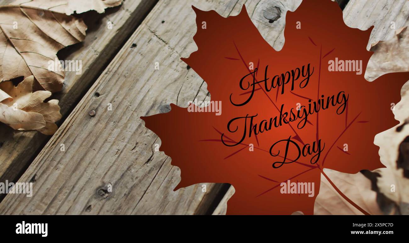 Immagine del testo del felice giorno del ringraziamento su foglie autunnali su sfondo di tavole di legno Foto Stock