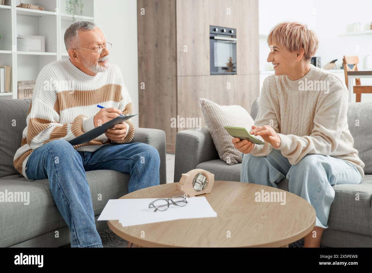 Coppia matura che tiene i registri dei contanti a casa Foto Stock