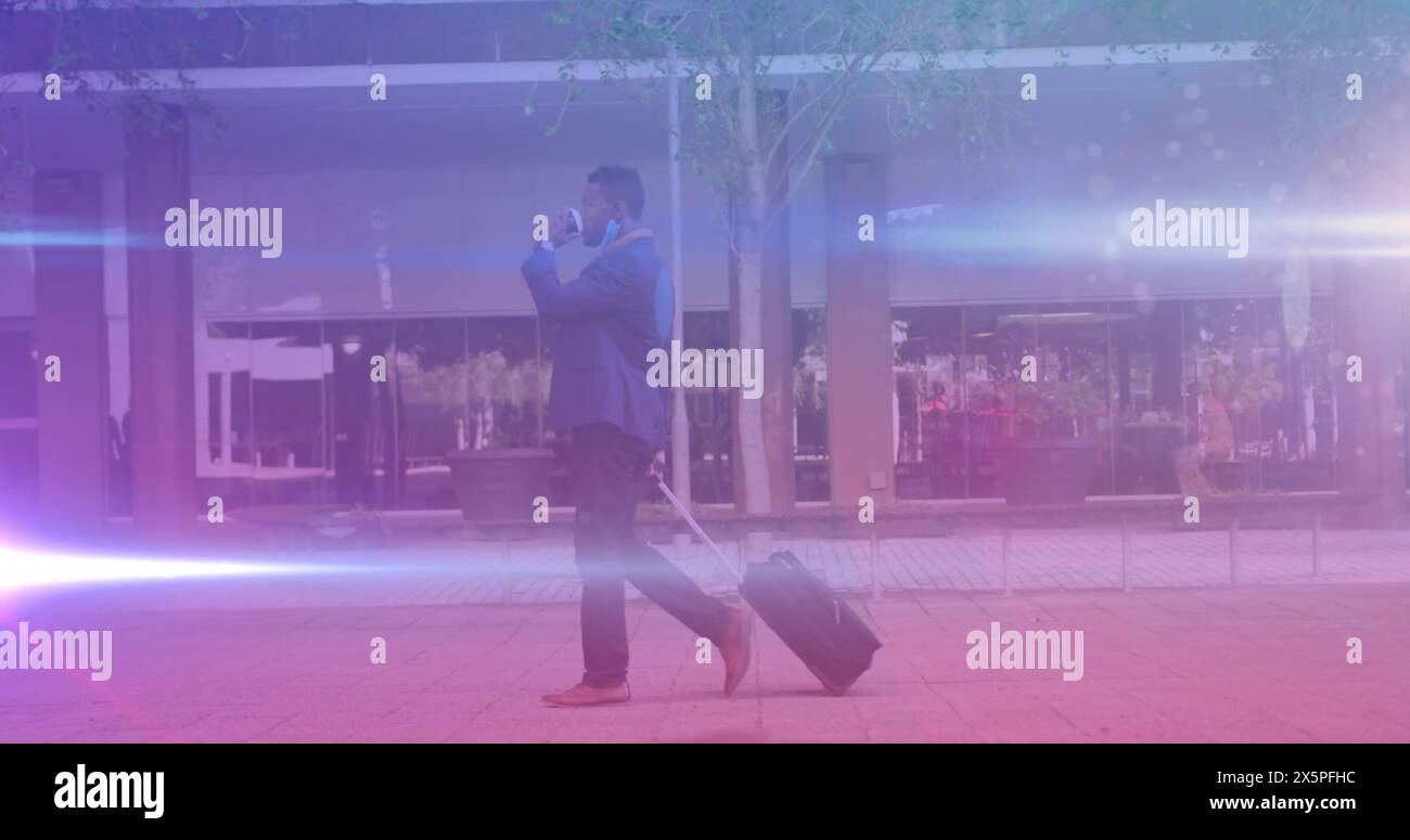 Uomo d'affari afroamericano che cammina, parla con lo smartphone Foto Stock