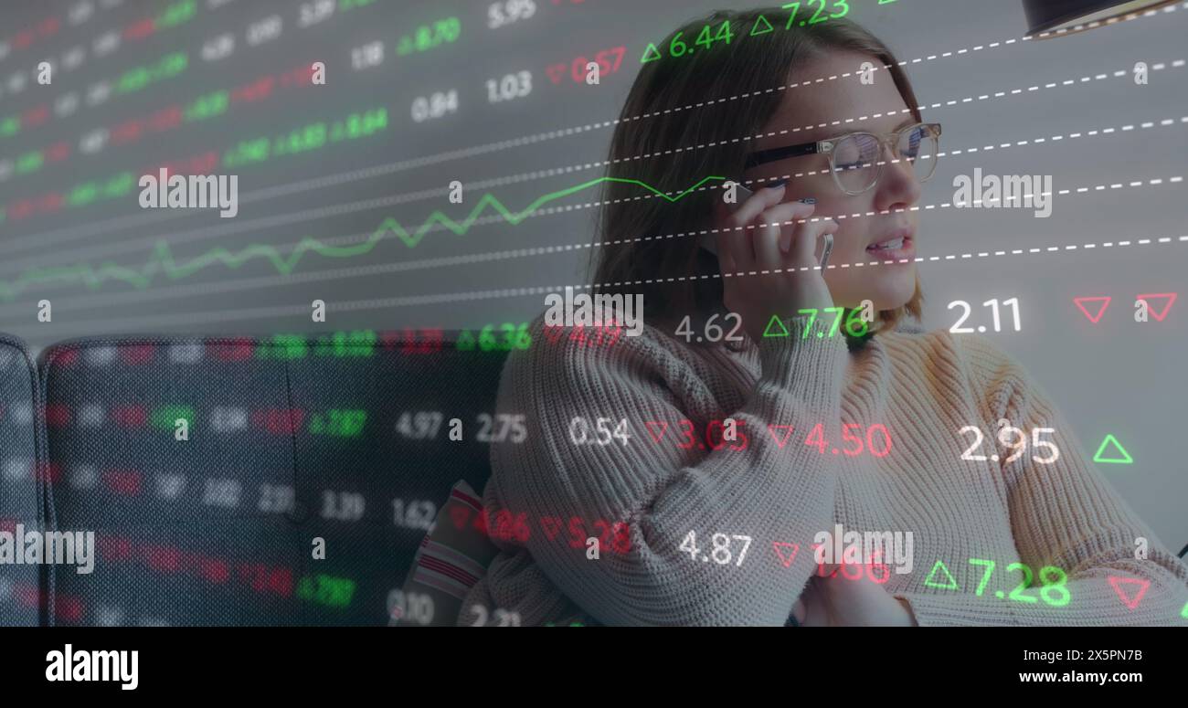 Immagine di un trading board multicolore, donna caucasica seduta sul divano e che parla al cellulare Foto Stock