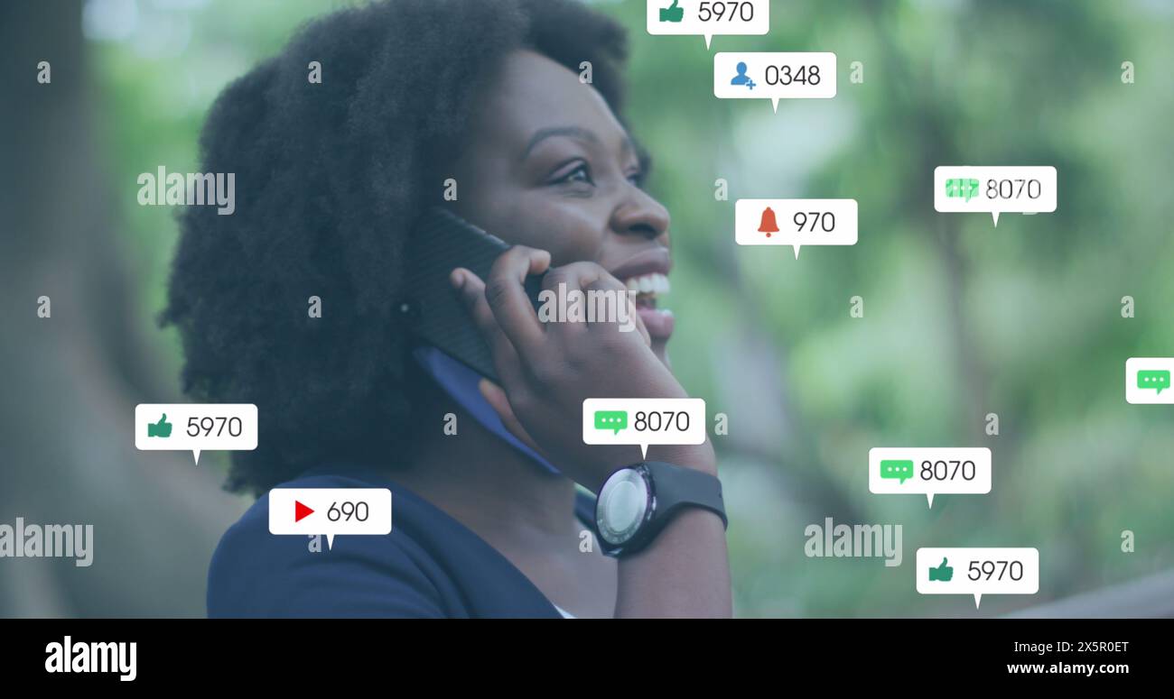 Assistente cuoco afroamericano, giovane, che parla su smartphone, sorride Foto Stock