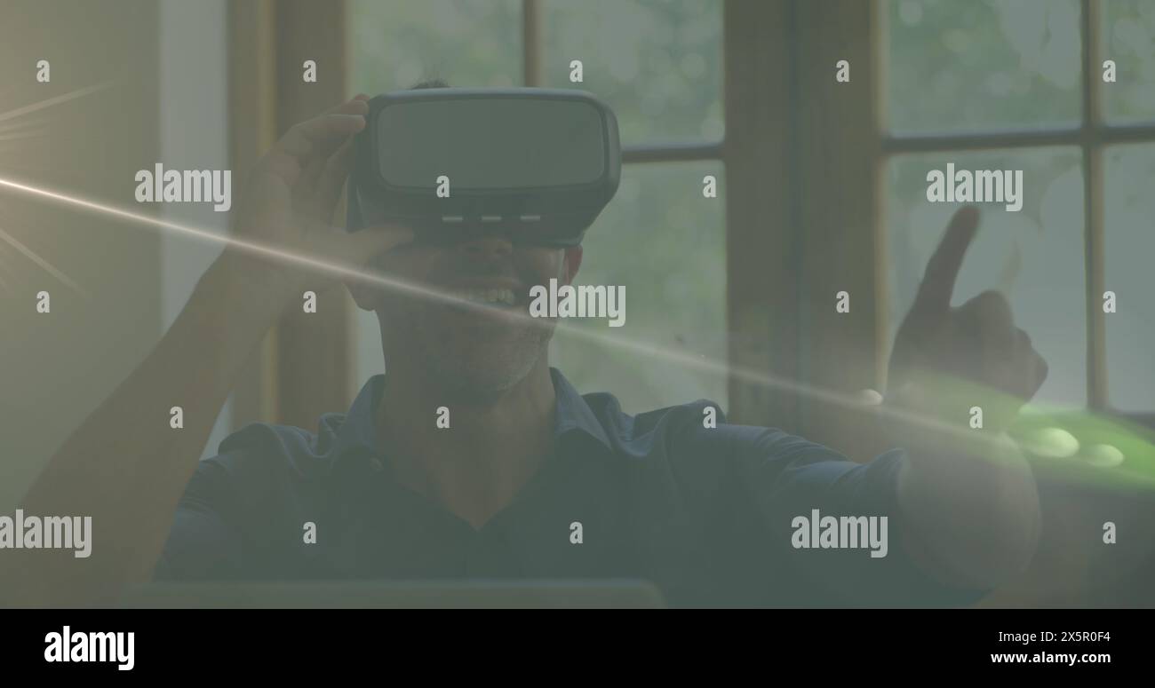 Chef caucasico maschile che indossa un visore per la realtà virtuale, punta Foto Stock