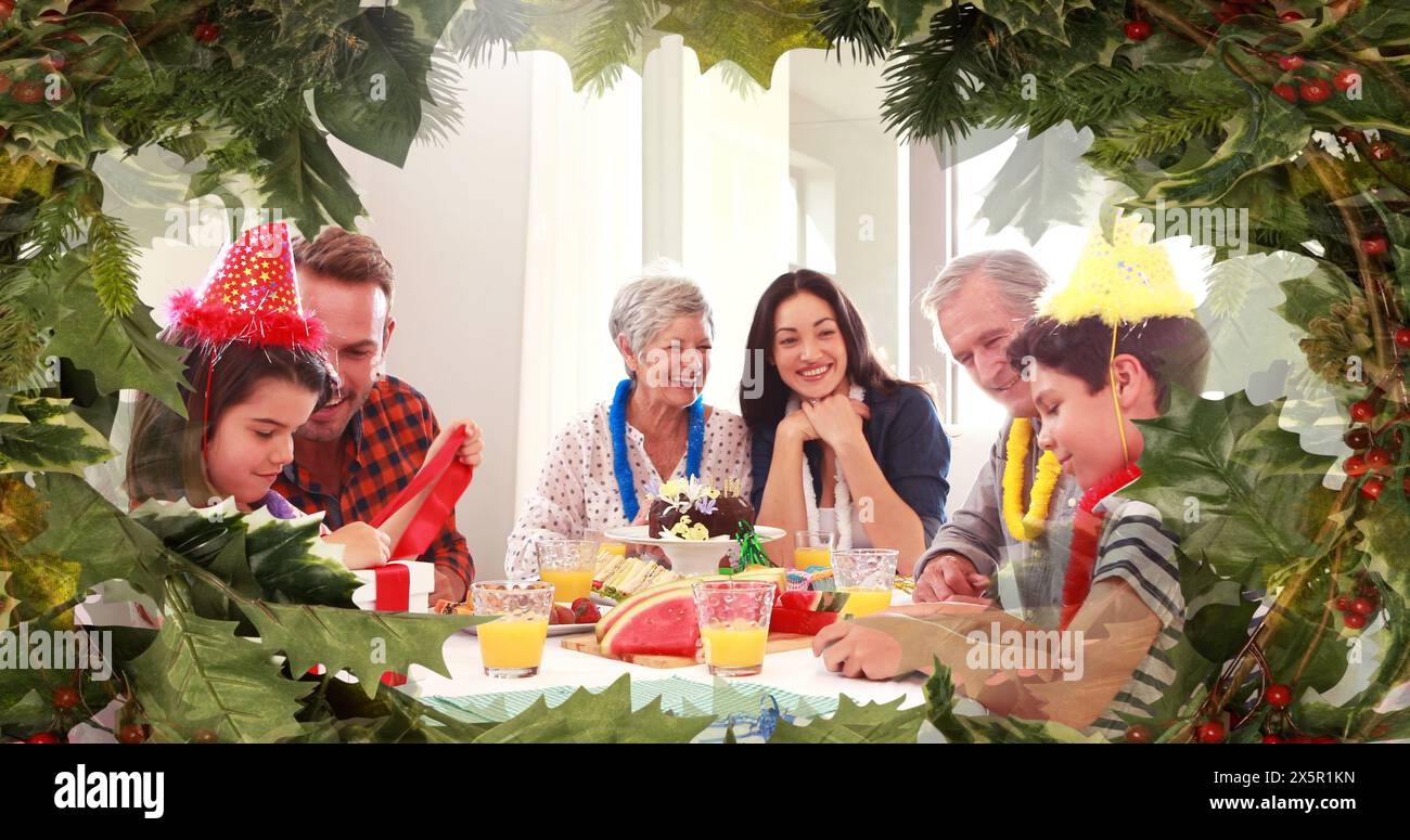 La famiglia caucasica gode di un pasto festivo in mezzo a decorazioni natalizie Foto Stock