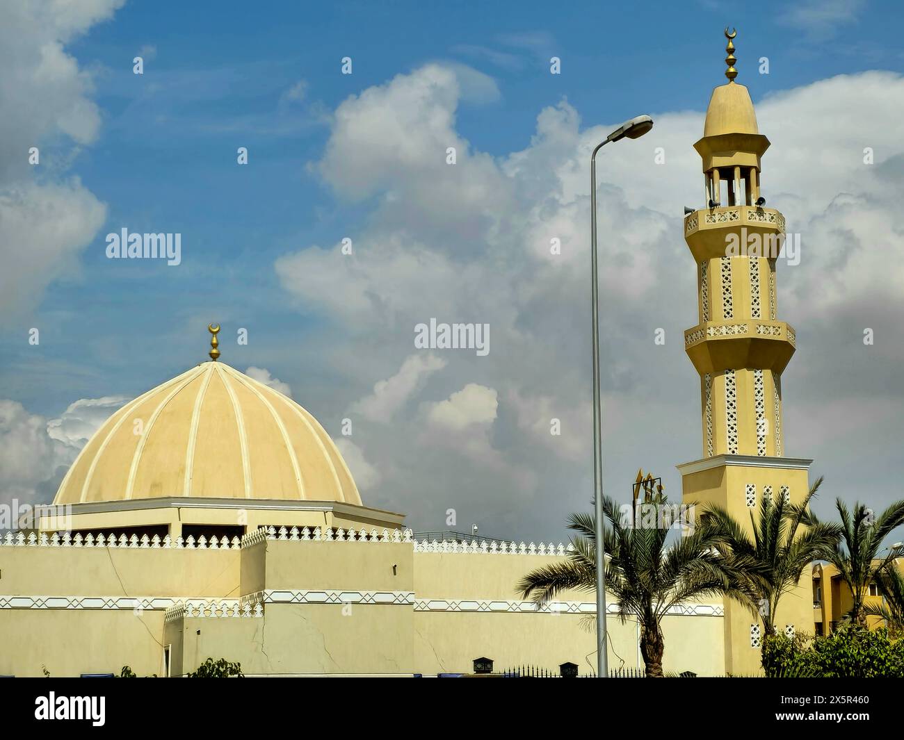 Cairo, Egitto, 24 marzo 2024: Alto minareto e cupola di una moschea contro un bel cielo blu con nuvole alla luce del giorno, le moschee sono il luogo ideale per il worshi Foto Stock