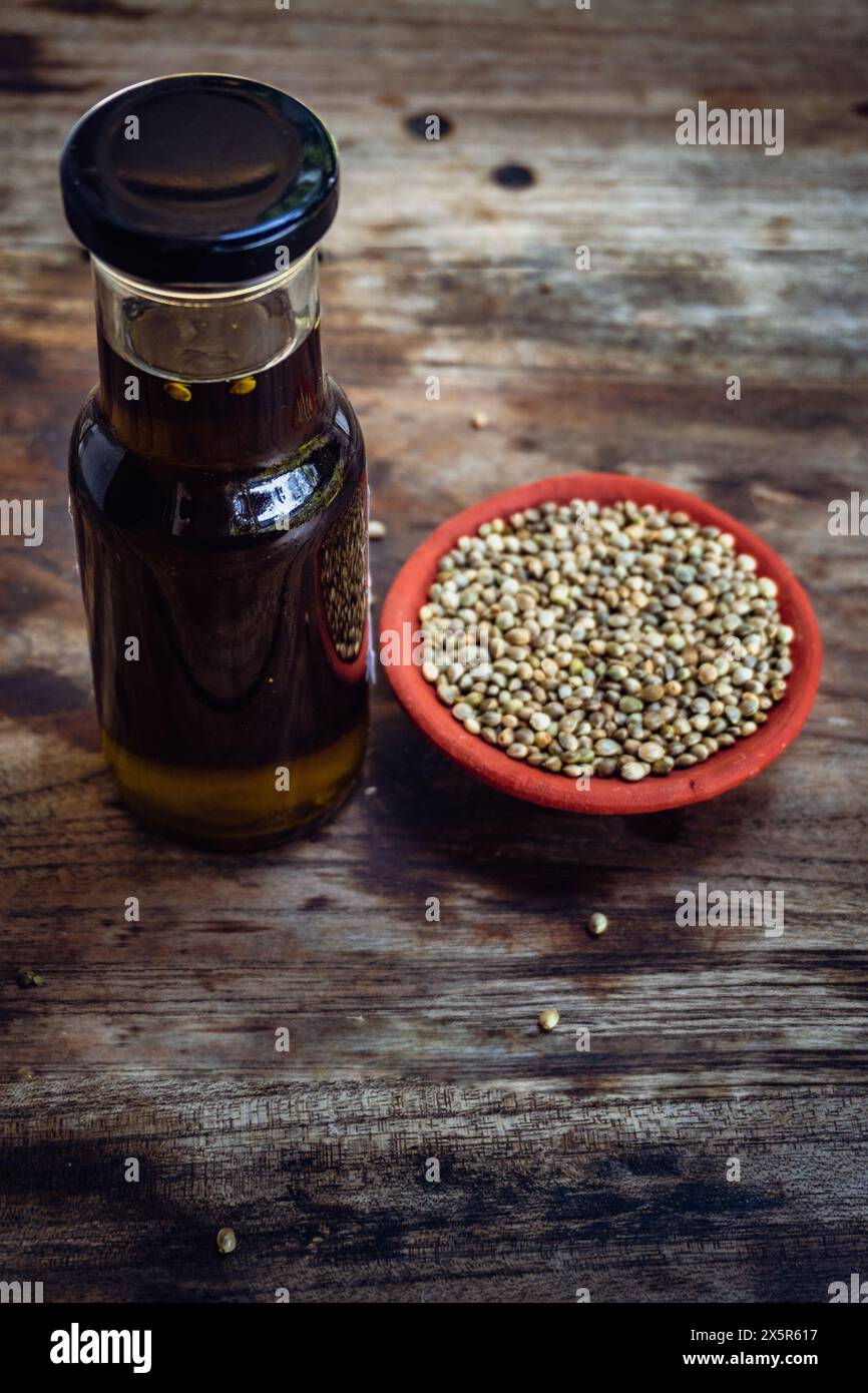 Bottiglie di olio di semi di canapa e semi su un tavolo rustico in legno. Foto Stock