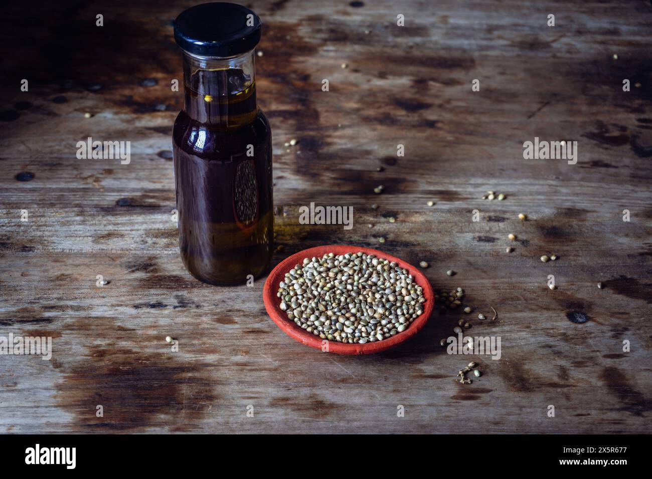 Bottiglie di olio di semi di canapa e semi su un tavolo rustico in legno. Foto Stock