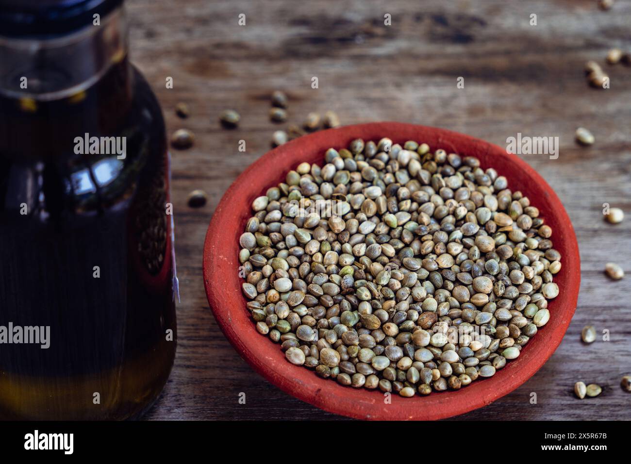 Bottiglie di olio di semi di canapa e semi su un tavolo rustico in legno. Foto Stock