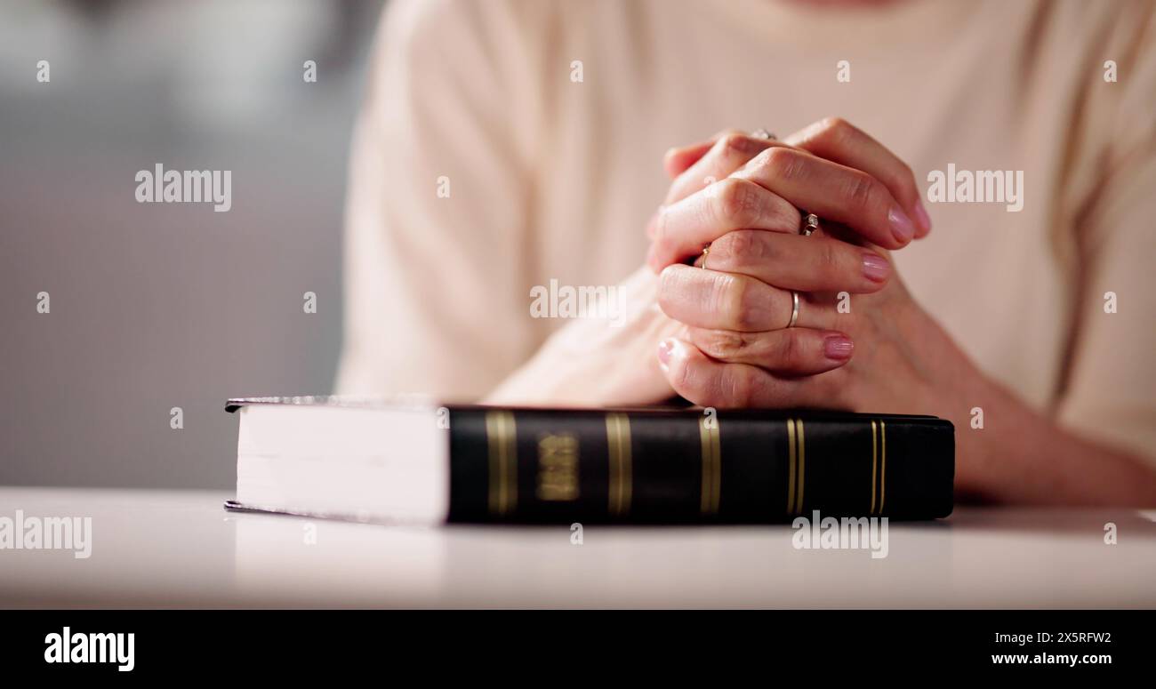 La mano della donna sul Libro della Bibbia. Preghiera cristiana Foto Stock
