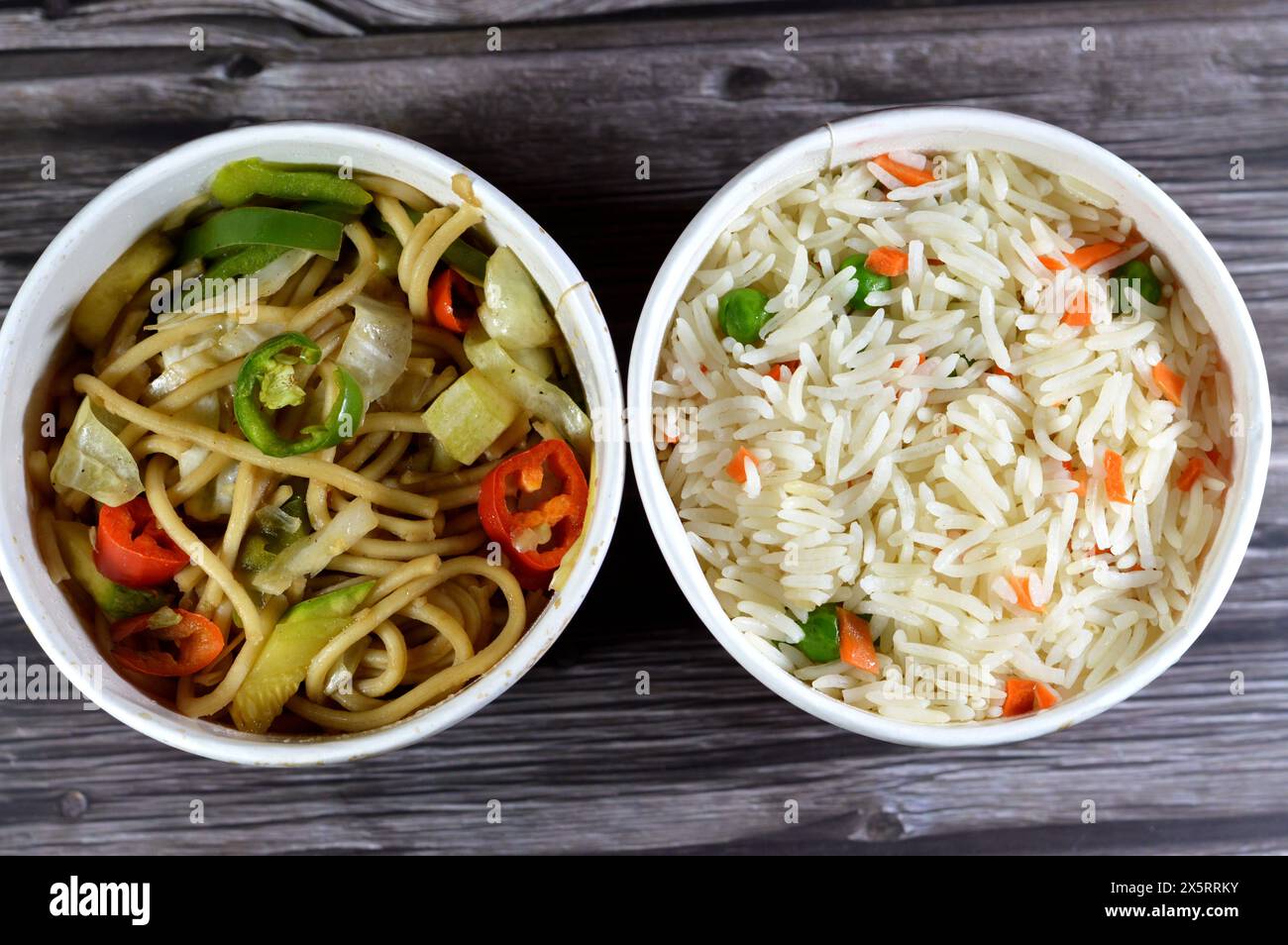 Spaghetti e riso sulla cucina asiatica, cibo cinese, riso basmati bianco a grani lunghi con verdure, carote e piselli e spaghetti cinesi con cipolle e così via Foto Stock